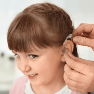 Small child putting in hearing aid