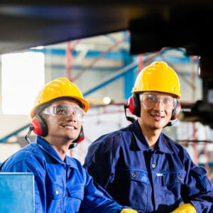 two men in warehouse wearing hearing protection