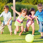 Kids are excitedly playing outside in a group.